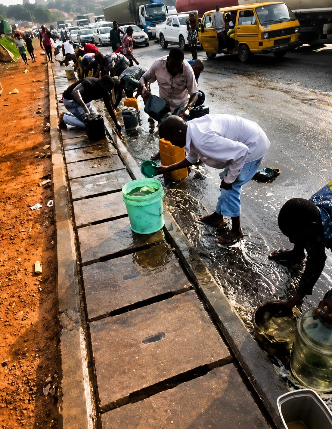 Residents scoop diesel from an overturned tanker at Tincan Liverpool Bridge in Lagos